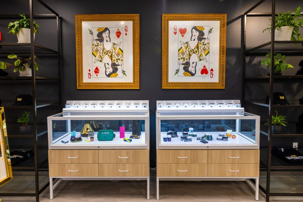 Queen City Dispensary store interior with large framed playing cards and accessories display