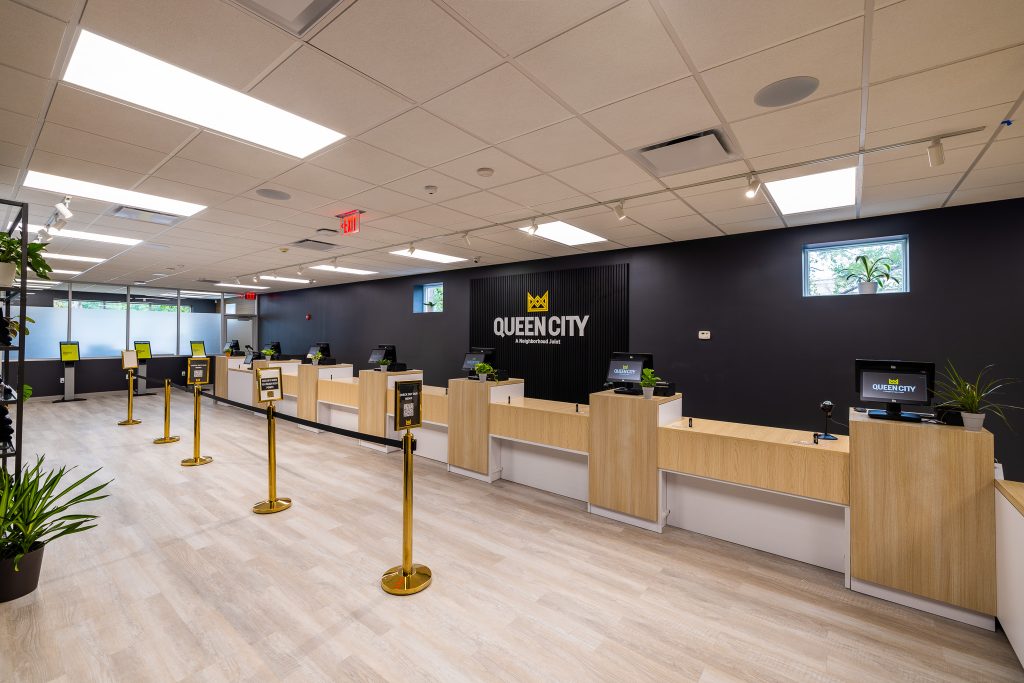 Queen City Dispensary store interior with registers, kiosks and gold stanchions.