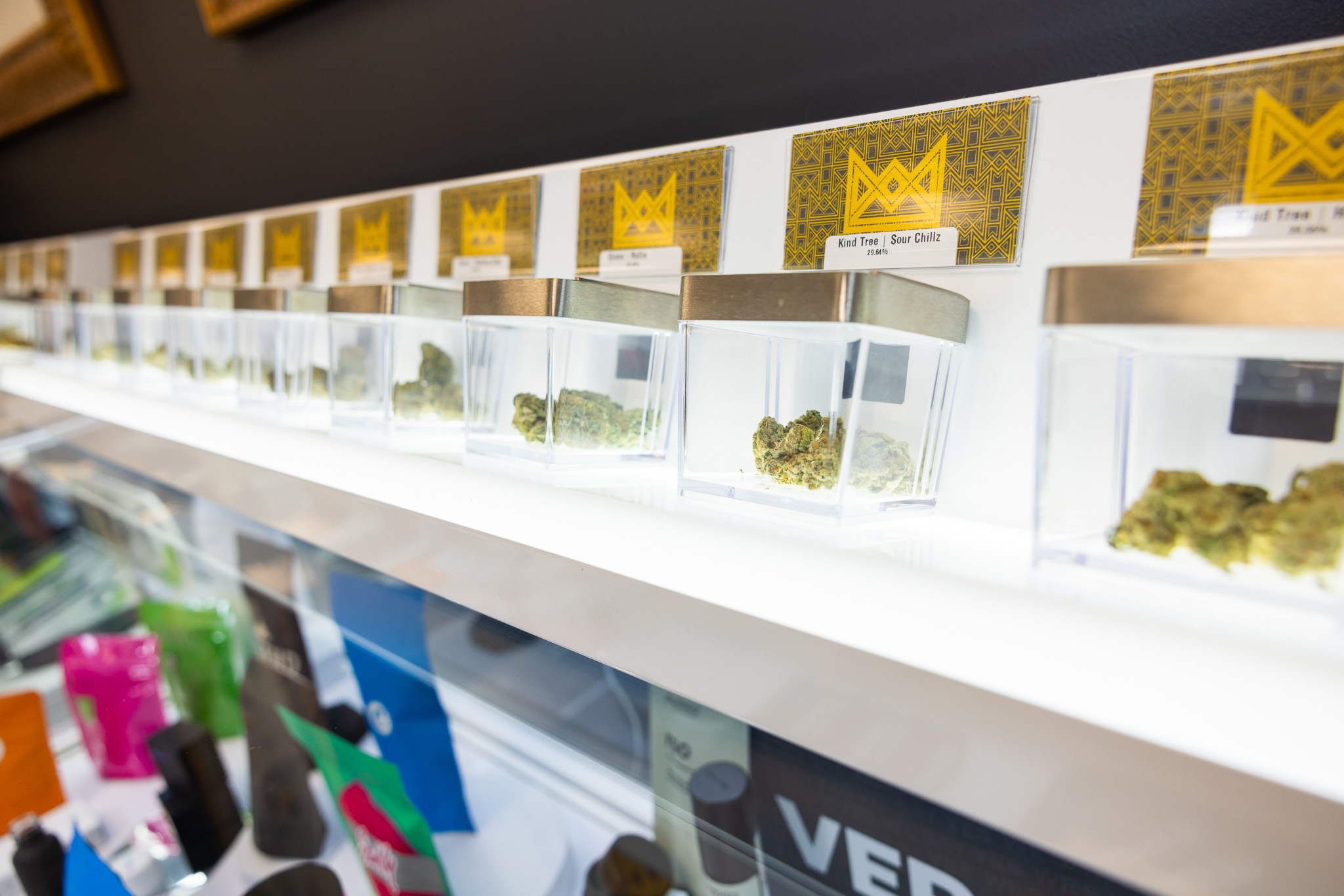 A line of containers displaying cannabis flower at Queen City Dispensary