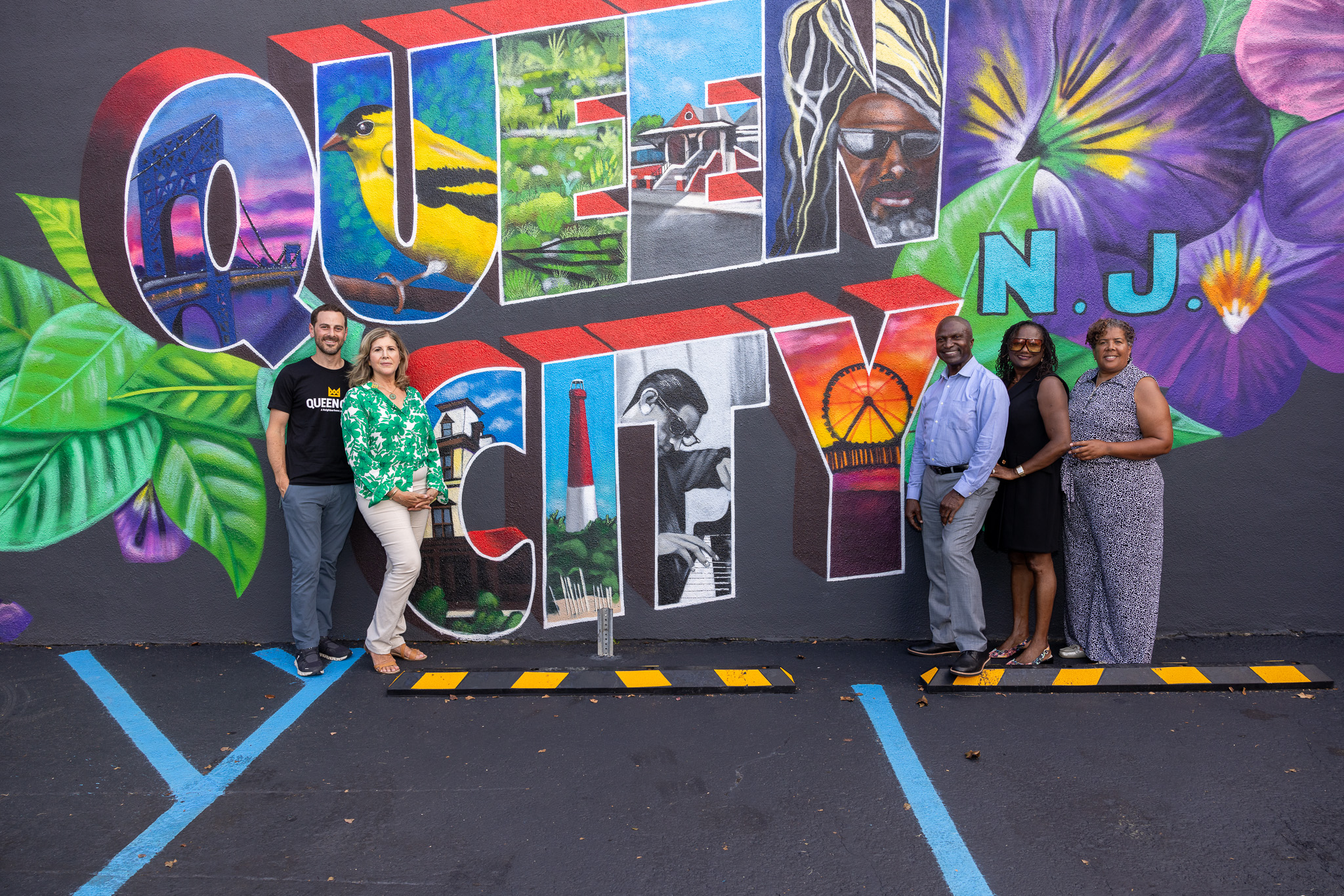 Queen City owner Jennifer Brandt and team member Justin Singer pose with city of Plainfield officials in front of the Queen City mural outside the dispensary.