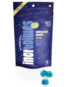 A package of Incredibles Snooozeberry edibles can be seen. Three blue edibles can be seen outside the package. The package itself is a navy blue bag with a nighttime sky depiction in the background.