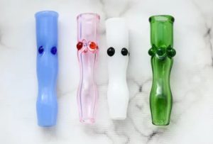 Four glass joint folders from House of Puff are depicted. Blue, pink, white, and green joint holders are depicted from left to right.