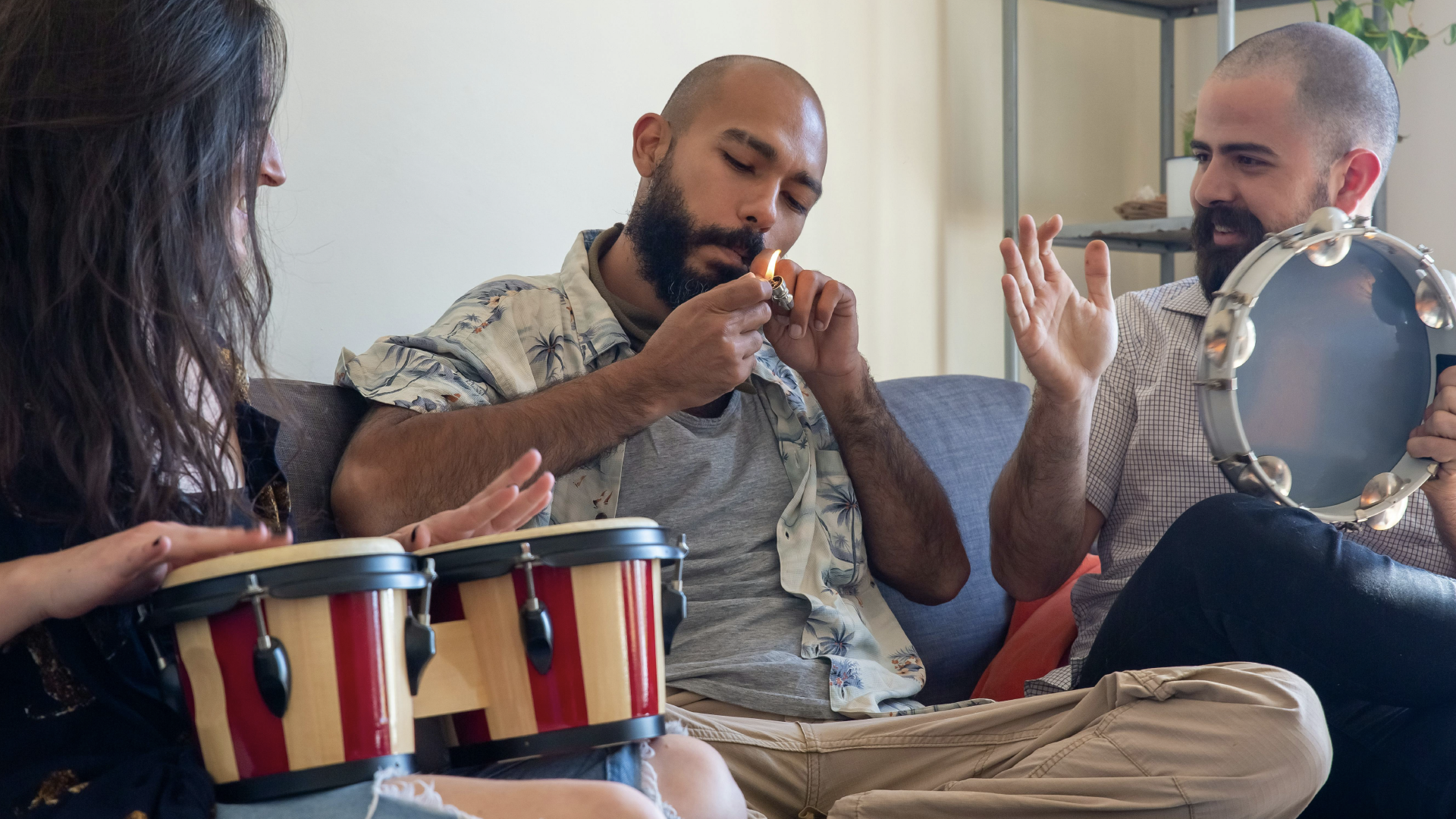 Man smoking a joint with friends on couch.