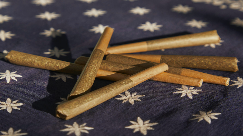 Pile of pre rolls on navy blue fabric with white stars