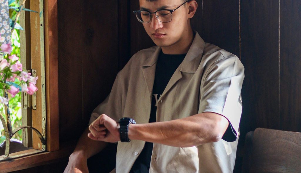 Person wearing glasses looking at wristwatch