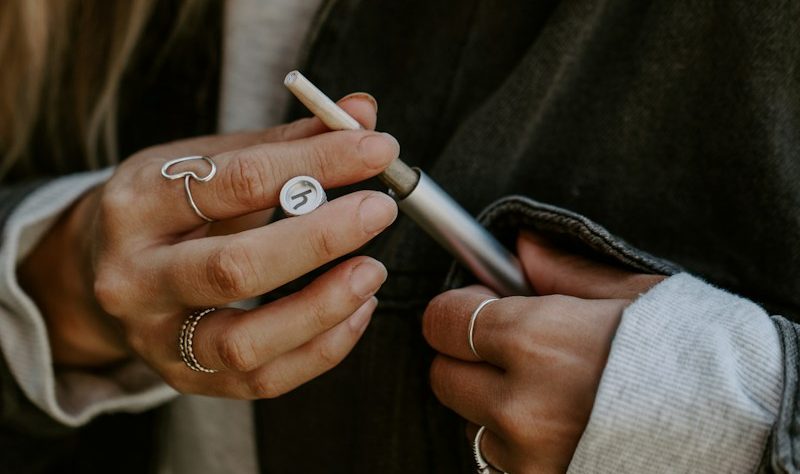 a woman is holding a cigarette and looking at her phone